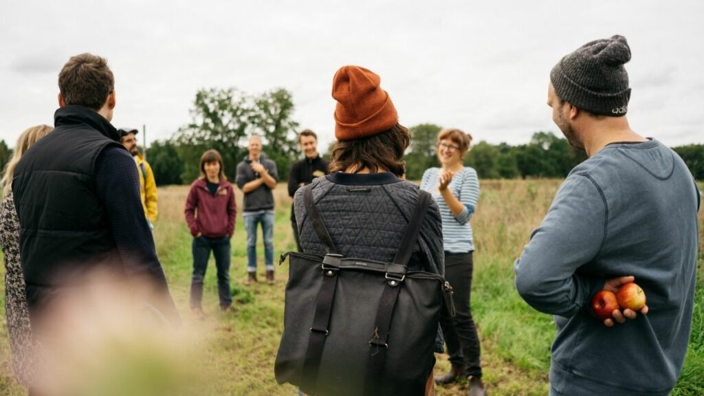 Crowdfunding in der Landwirtschaft - Menschen auf dem Feld bekommen etwas erklärt